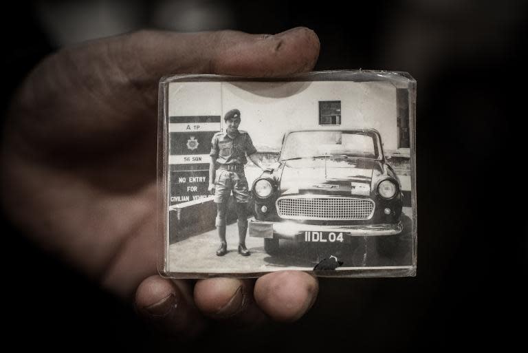 Leung Wai-sang, 70, who was a driver while serving in the colonial-era transport corps in the 1960s, shows a photograph of himself in uniform in Hong Kong