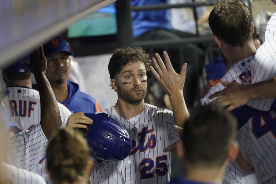 New York Mets' Tyler Naquin (25) celebrates after scoring off a bases loaded walk by Pittsburgh Pirates pitcher Eric Stout during the sixth inning of a baseball game, Saturday, Sept. 17, 2022, in New York. (AP Photo/Mary Altaffer)