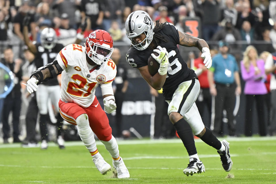 Las Vegas Raiders wide receiver Jakobi Meyers, right, scores on a touchdown reception against Kansas City Chiefs safety Mike Edwards during the first half of an NFL football game, Sunday, Nov. 26, 2023, in Las Vegas. (AP Photo/David Becker)