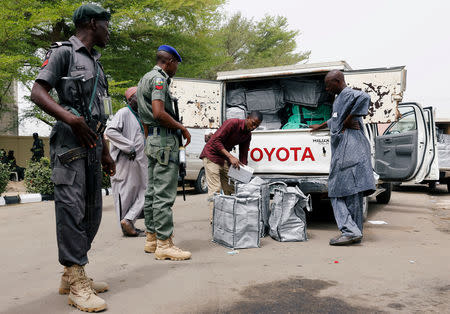 Police members oversee Ad-hoc staff loading boxes onto a truck during the distribution of election materials at the INEC office in Yola, Adamawa State, Nigeria February 15, 2019. REUTERS/Nyancho NwaNri