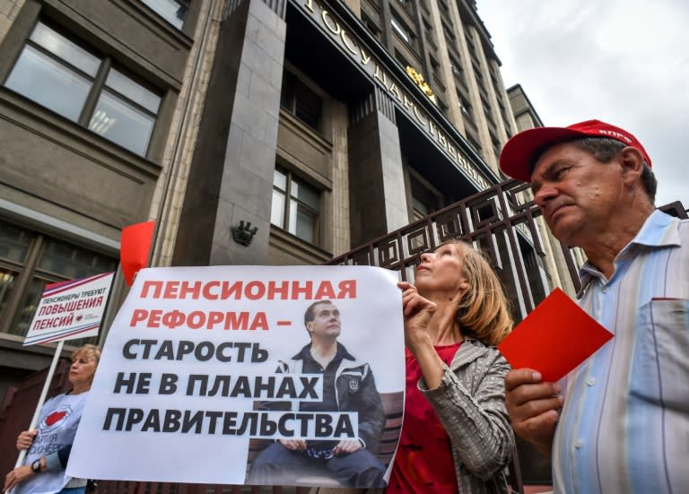 A woman holds a poster reading "Pension reform - old age is not in the plans of the government" during a rally against government plans -- approved by parliament later Thursday -- to increase the retirement age