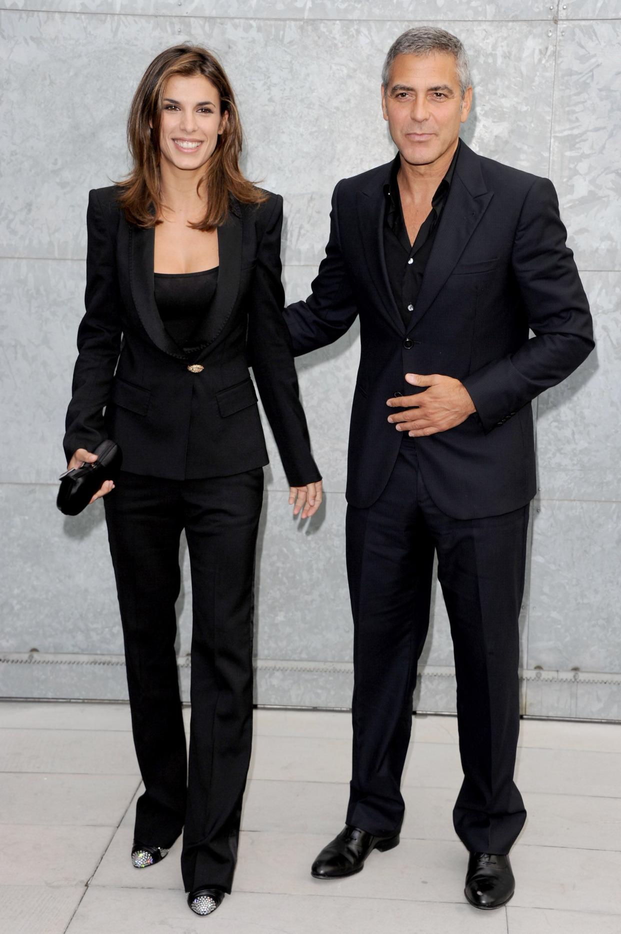 Clooney and Elisabetta Canalis at the Giorgio Armani Spring/Summer fashion show during Milan Fashion Week Womenswear.