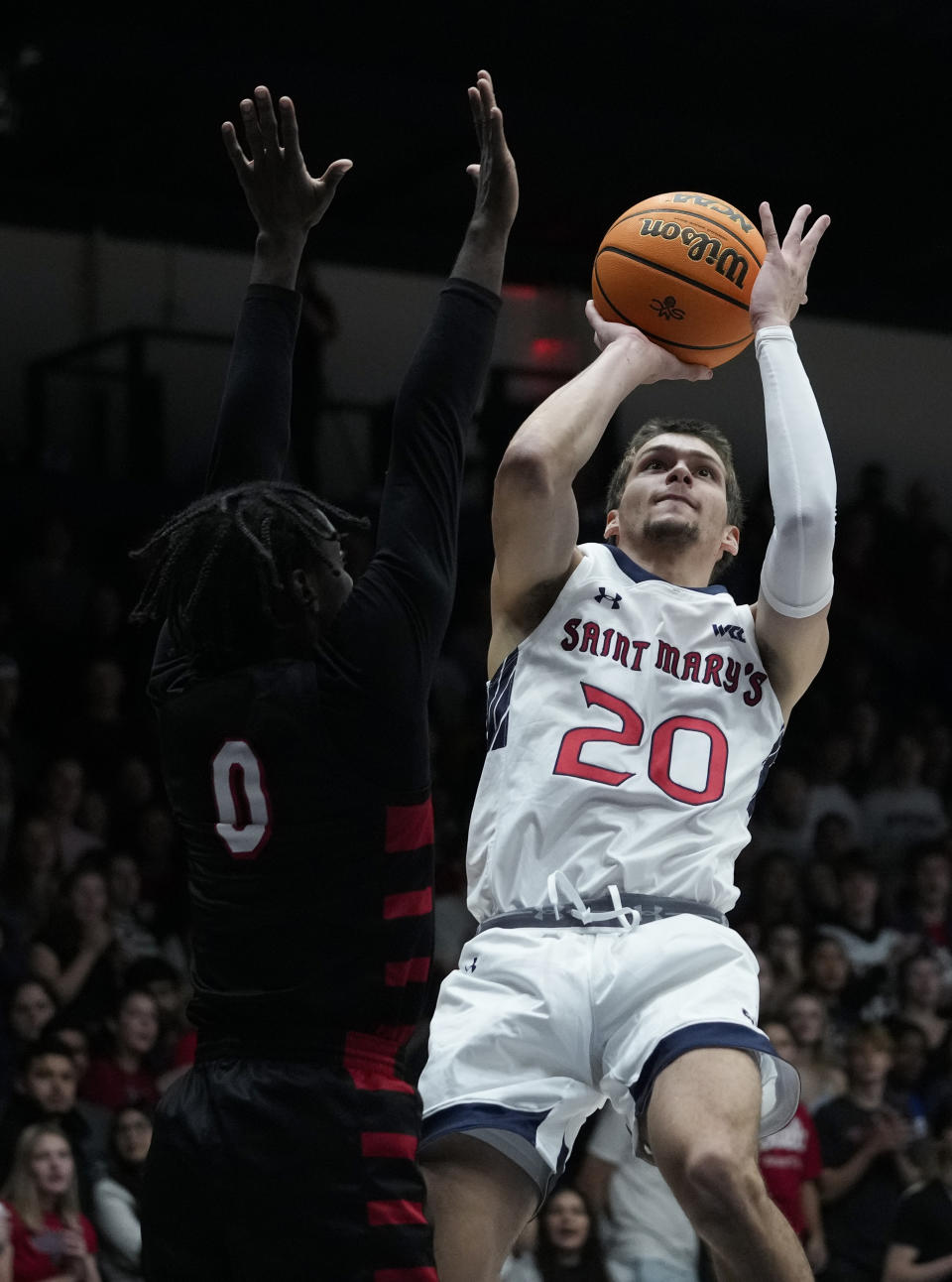 Saint Mary's guard Aidan Mahaney (20) shoots while defended by Cal State Stanislaus guard Jeremiah Jones during the first half of an NCAA college basketball game Monday, Nov. 6, 2023, in Moraga, Calif. (AP Photo/Godofredo A. Vásquez)