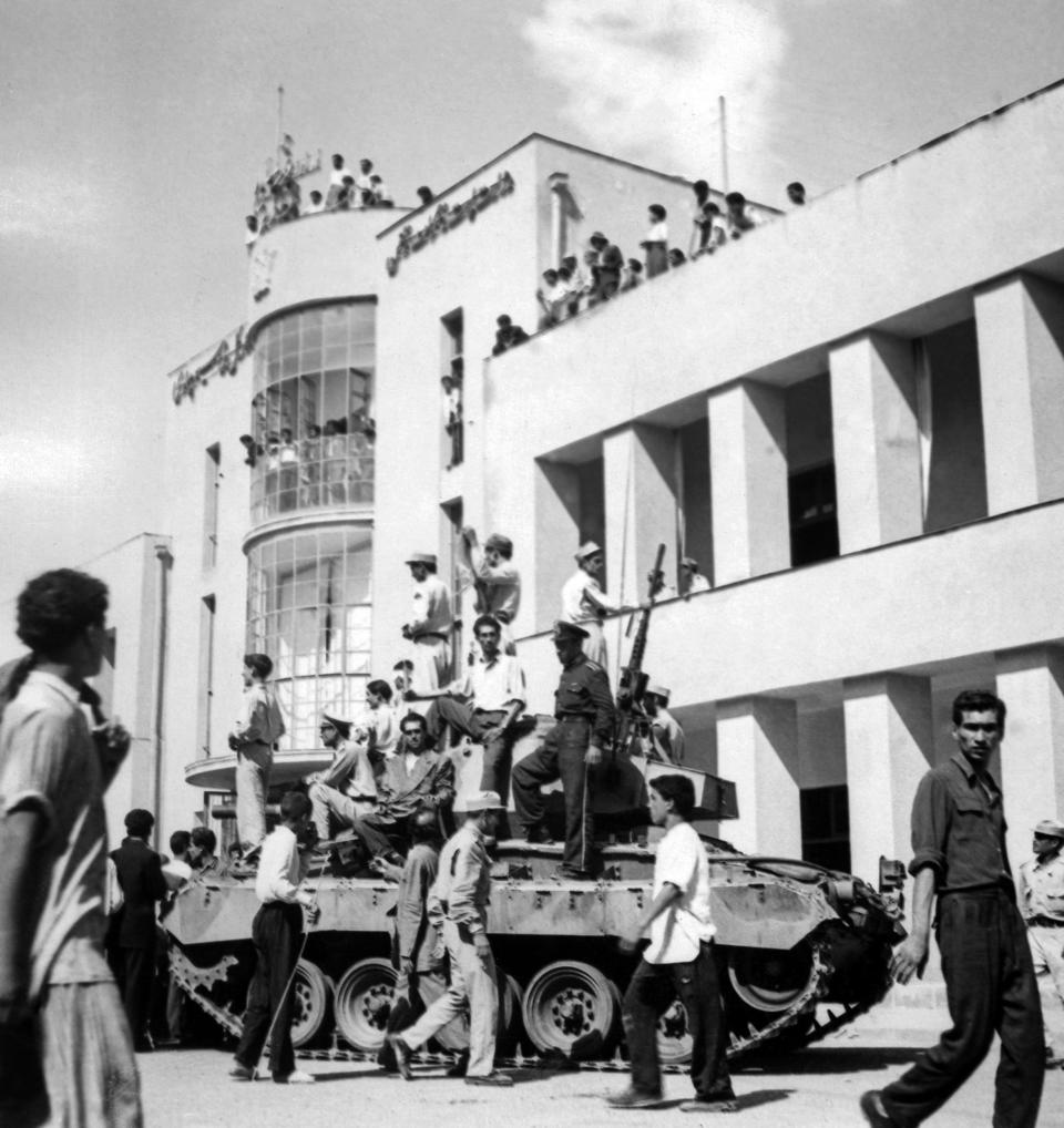 FILE - In this Aug. 19, 1953 file photo, a royalist tank moves into the courtyard of Tehran Radio a few minutes after pro-shah troops occupied the place during the coup which ousted Prime Minister Mohammad Mossadegh and his government. In 2018, as Iran deals with President Donald Trump's decision to pull America from the nuclear deal with world powers, more are invoking the 1953 CIA-backed coup that toppled Mossadegh as proof the U.S. cannot be trusted. (AP Photo, File)