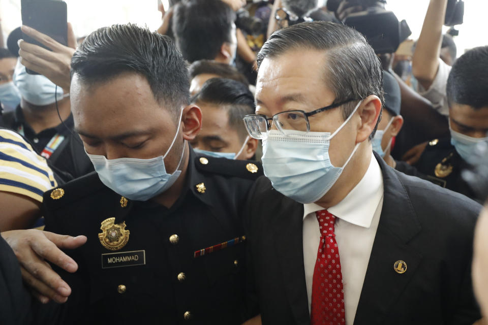 Former Finance Minister and Penang chief minister Lim Guan Eng, right, escorted by Anti Corruption officer, arrives at courthouse in Kuala Lumpur, Malaysia, Friday, Aug. 7, 2020. Lim was arrested last night to be charged with corruption in connection with the Penang undersea tunnel project, the Malaysian Anti-Corruption Commission (MACC). (AP Photo/Vincent Thian)