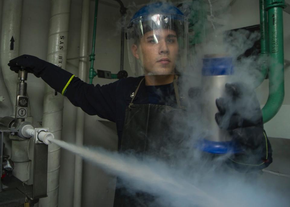 Petty Officer 3rd Class Austin Huizar samples liquid nitrogen in the cryogenics shop aboard the aircraft carrier USS George Washington, October 14, 2016.