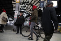 Commuters walk to get on a train at the Gare Saint Lazare station in Paris, France, Monday, Dec. 16, 2019. French transport strikes against a planned overhaul of the pension system entered their twelfth day Monday as French president Emmanuel Macron's government remains determined to push ahead with its plans. (AP Photo/Francois Mori)