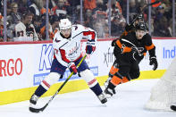 Washington Capitals' T.J. Oshie, left, passes the puck as Philadelphia Flyers' Travis Sanheim (6) skates during the third period of an NHL hockey game, Saturday, Feb. 26, 2022, in Philadelphia. (AP Photo/Derik Hamilton)