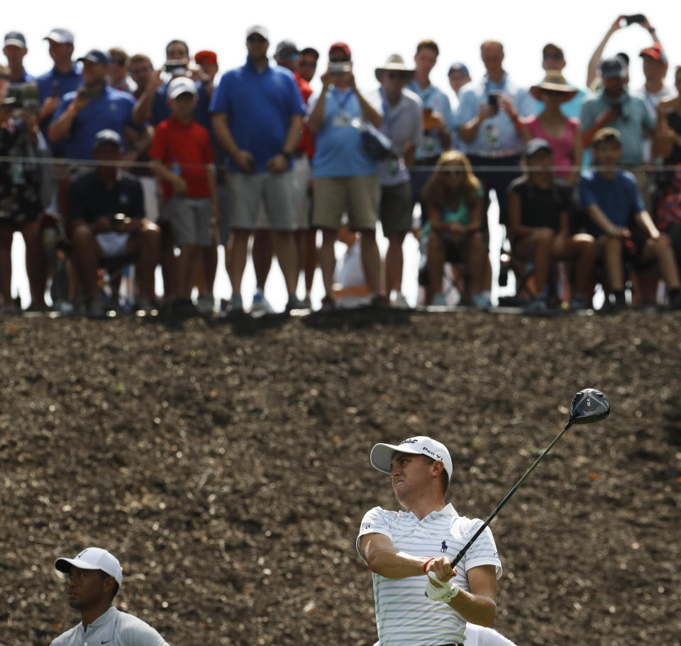 Spectators watch from above as Justin Thomas drives on the eighth hole as Tiger Woods watches at lower left, during the second round of the PGA Championship golf tournament at Bellerive Country Club, Friday, Aug. 10, 2018, in St. Louis. (AP Photo/Charlie Riedel)