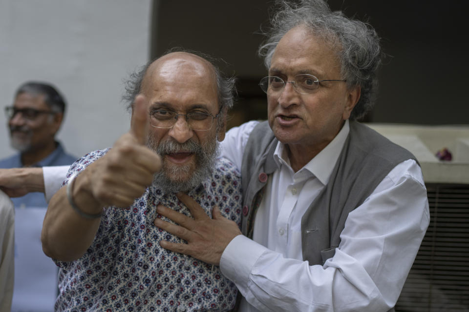 Paranjoy Guha Thakurta, left, a senior journalist and columnist associated with NewsClick, who was one of the 46 people detained by Delhi police Tuesday, gestures a thumbs up sign as Ramchandra Guha, right, a historian, embraces him, as they meet during a protest at press club of India in New Delhi, India, Wednesday, Oct. 4, 2023. Police in New Delhi on Tuesday arrested the editor of a news website and one of its administrators after raiding the homes of journalists working for the site, which has been critical of Prime Minister Narendra Modi and his Hindu nationalist-led government. (AP Photo/Altaf Qadri)