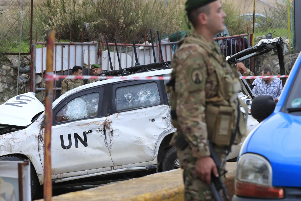 Lebanese soldiers stand next to a damaged UN peacekeeper vehicle at the scene where a UN peacekeeper convoy came under gunfire in the Al-Aqbiya village, south Lebanon, Thursday, Dec. 15, 2022. (AP Photo/Mohammed Zaatari)