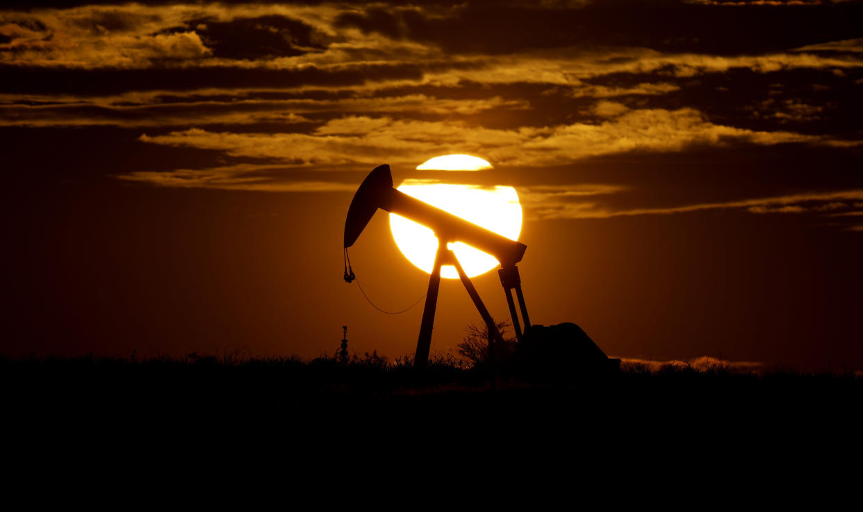 FILE - The sun sets behind an idle pump jack near Karnes City, Texas, April 8, 2020. Texas can feel like a study in contrasts. One example being that the state is famed for its oil industry, but is the producer of a quarter of the country’s wind energy and a leader in solar power. (AP Photo/Eric Gay, File)