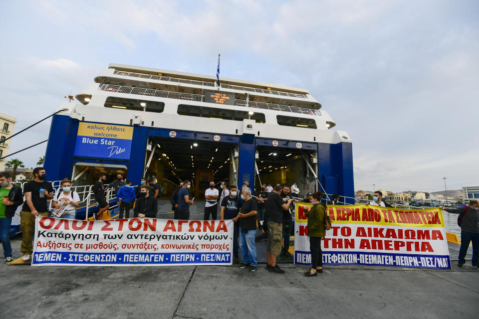 Protesters block the entrance of a passenger ferry during a 24-hour labour strike at the port of Piraeus, near Athens, Thursday, June 10, 2021. Greece's biggest labor unions stage a 24-hour strike to protest a draft labor bill being debated in parliament, which workers say will erode their rights. (AP Photo/Michael Varaklas)