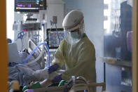 A healthcare worker tends to a COVID-19 patient in the intensive care unit at Santa Clara Valley Medical Center during the coronavirus pandemic in San Jose, Calif., Wednesday, Jan. 13, 2021. (AP Photo/Jeff Chiu)