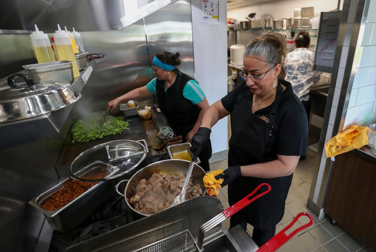 Leticia Salazar, right, and Maria Luisa Delgado Hernandez cook food at Los Tejados Mexican Restaurant in Green Bay. The restaurant opened for its first day of business on Wednesday.