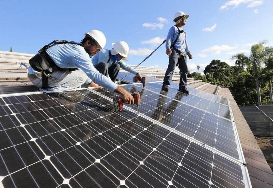 Workers install solar panels at a home in South Miami-Dade County in 2015.