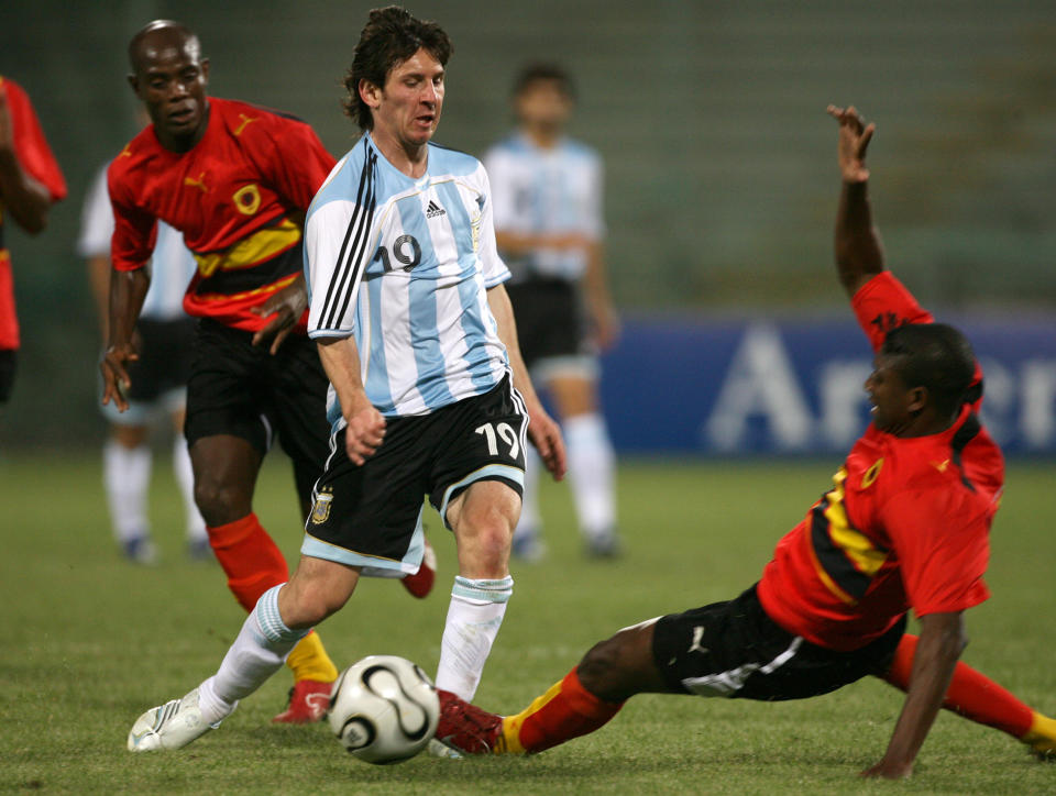 FILE - In this May 30, 2006, file photo, Argentina's Lionel Messi dribbles past an unidentified Angola player during an exhibition soccer match in Salerno, Italy. In Spain, young soccer players can sign professional contracts when they turn 16, the minimum work age stipulated by Spanish law. Before that, children join training academies run by soccer clubs that field youth teams in amateur leagues. The most well-known example in Spain is Barcelona's "La Masia" academy, where Lionel Messi started training at the age of 13 when his family emigrated from Argentina. (AP Photo/Francesco Pecoraro, File)