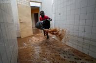 Volunteer removes water from a flooded health center after heavy rains in Guediawaye on the outskirts of Dakar