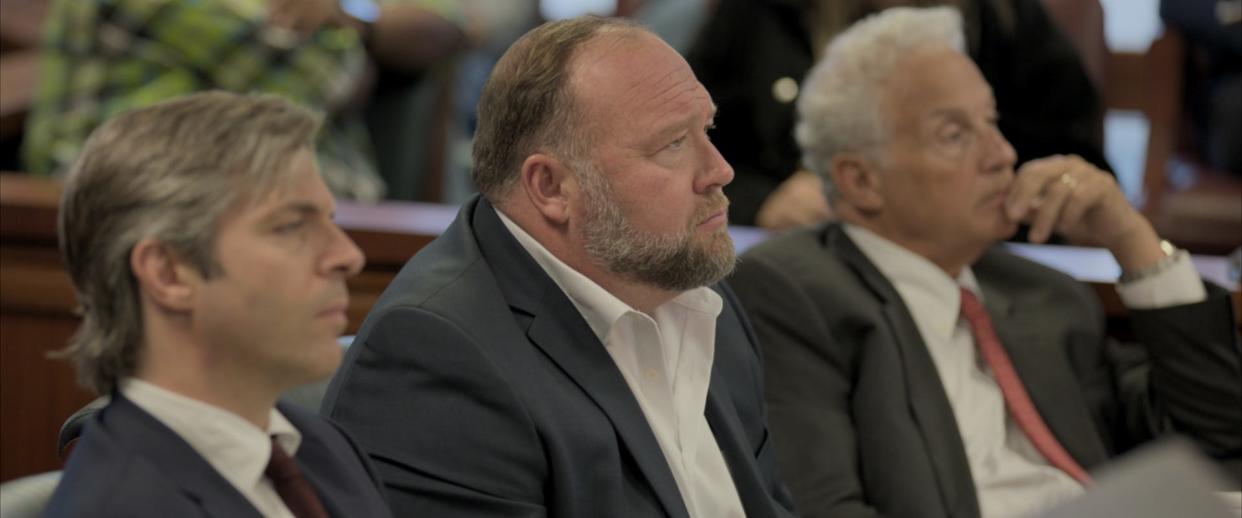 Alex Jones, center, appears in a courtroom with his attorneys in a moment captured for the HBO documentary "The Truth vs. Alex Jones."