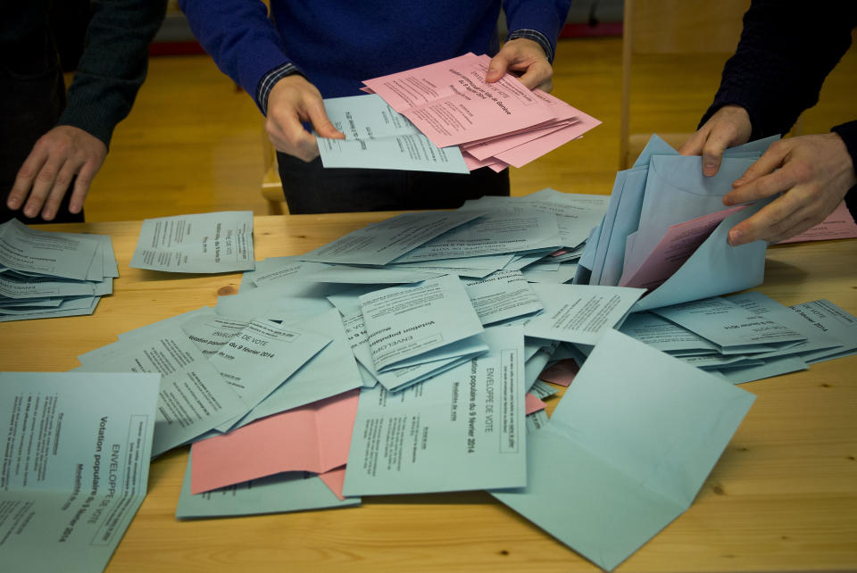 Electoral workers sort out voting papers after emptying the ballot boxes at a makeshift polling station after Swiss voters went to the polls to decide on a proposal to cap immigration to the Alpine republic, in the center of Geneva, Switzerland, Sunday, Feb. 9, 2014. The nationalist Swiss People’s Party demands a stop for immigration to Switzerland. (AP Photo/Anja Niedringhaus)