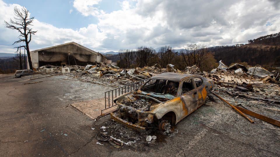 A charred car and the remains of the Swiss Chalet Hotel are pictured after being destroyed by the South Fork Fire in the mountain village of Ruidoso, New Mexico, on Saturday. - Andres Leighton/AP