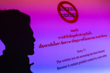 FILE PHOTO: A man is silhouetted onto an electronic screen displaying prohibited website in Bangkok, Thailand, in this June 19, 2017 illustration photo. REUTERS/Athit Perawongmetha/Illustration/Files