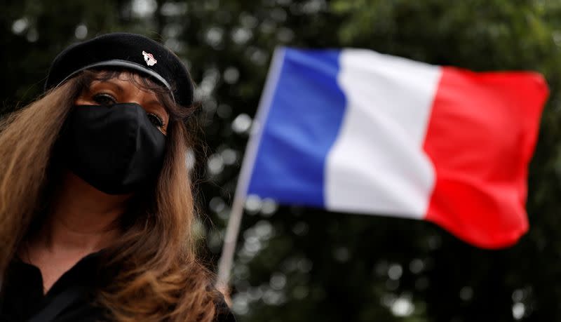 A supporter of police forces wears a protective face mask as she demonstrates in front of the French police headquarters in Paris