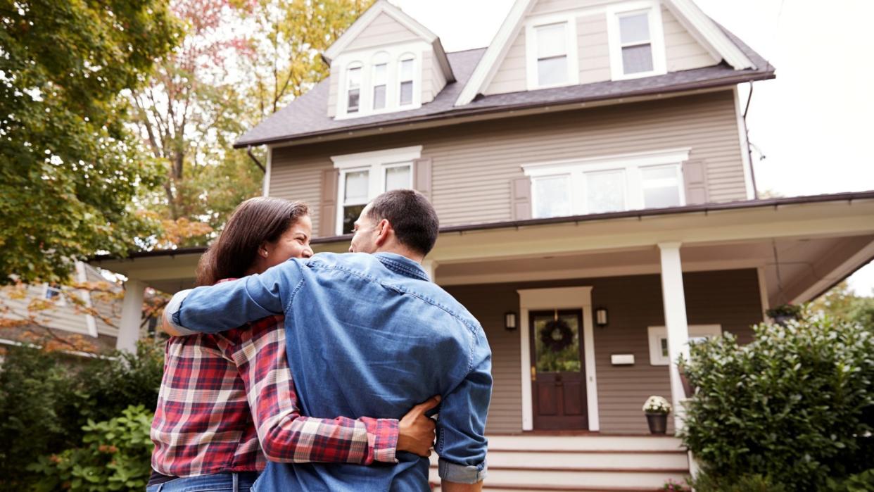 Rear View Of Loving Couple Walking Towards House.