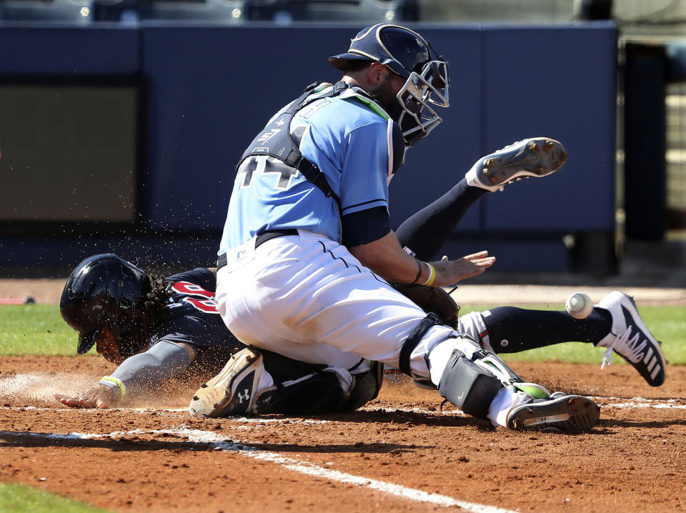 Atlanta Braves outfielder Justin Dean scores past Tampa Bay Rays catcher Kevan Smith on an RBI-single by Austin Riley to cut the Rays lead to 5-4 during the fourth inning of an MLB spring training baseball game at Charlotte Sports Park on Sunday, Feb. 28, 2021, in Port Charlotte, Fla. (Curtis Compton / Curtis/Atlanta Journal-Constitution via AP)