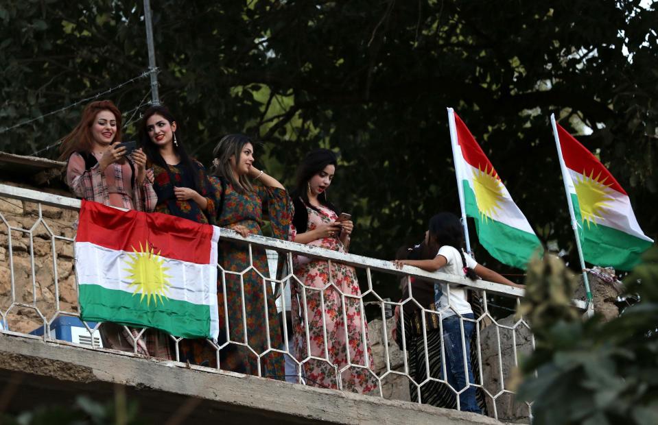 <p>Iraqi Kurdish woman stand next to Kurdish flags during a gathering on Sept. 10, 2017, to show support for the upcoming independence referendum and encourage people to vote in the town of Akra, some 300 miles north of Baghdad. (Photo: Safin Hamed/AFP/Getty Images) </p>