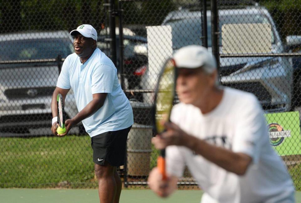 Councilman Malcolm Graham, left, gets ready to serve during a tennis match with his partner, Harry Walker, right, at Dilworth Elementary on Sunday, July 30, 2023.