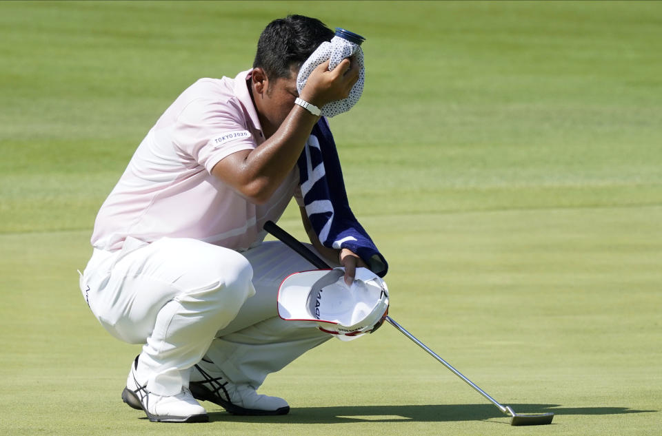 Hideki Matsuyama of Japan dries hi sweat on the 12th green during the third round of the men's golf event at the 2020 Summer Olympics Saturday, July 31, 2021, in Kawagoe, Japan. (AP Photo/Matt York)