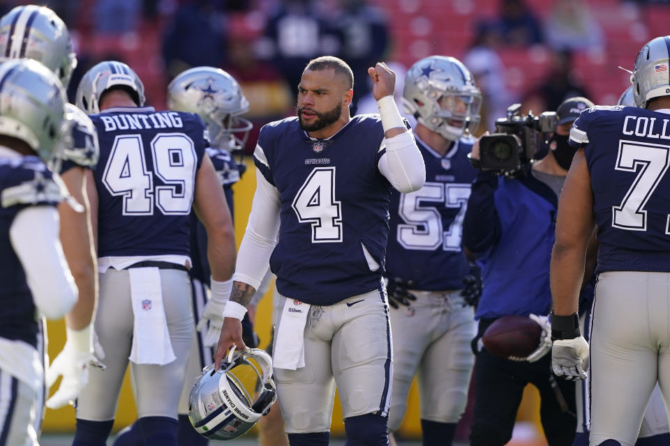 Dallas Cowboys quarterback Dak Prescott (4) gestures to his teammates during pregame warmups prior to the start of the first half of an NFL football game against the Washington Football Team, Sunday, Dec. 12, 2021, in Landover, Md. (AP Photo/Alex Brandon)