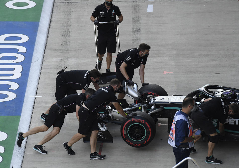 Pit crew push back the car of Mercedes driver Lewis Hamilton of Britain during the qualifying session for the upcoming Russian Formula One Grand Prix, at the Sochi Autodrom circuit, in Sochi, Russia, Saturday, Sept. 26, 2020. The Russian Formula One Grand Prix will take place on Sunday. (Kirill Kudryavtsev, Pool via AP)