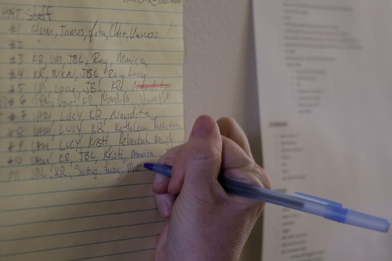 A medical worker records the names of Harborview Medical Center's home assessment team, which screens patients at their homes who may have been exposed to novel coronavirus, before departing for a patient's home, at Harborview Medical Center in Seattle