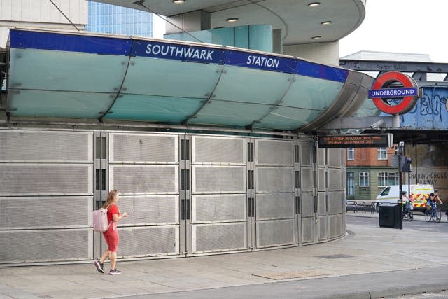 A woman walks past Southwark Underground Station