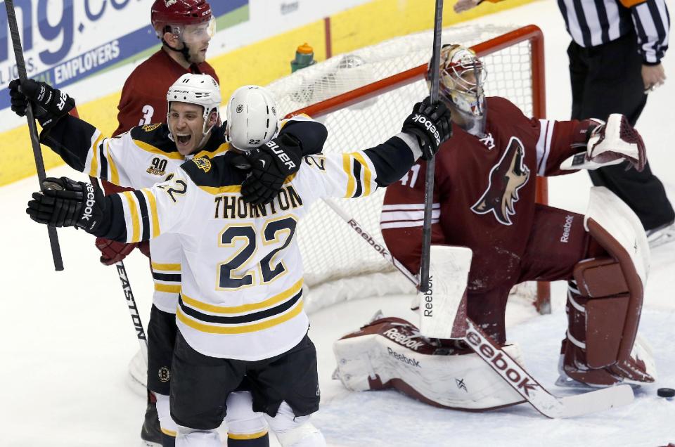 Boston Bruins' Shawn Thornton (22) celebrates his goal against Phoenix Coyotes' Mike Smith, right, with teammate Gregory Campbell (11) as Coyotes' Keith Yandle (3) skates past during the third period of an NHL hockey game Saturday, March 22, 2014, in Glendale, Ariz. The Bruins defeated the Coyotes 4-2. (AP Photo/Ross D. Franklin)