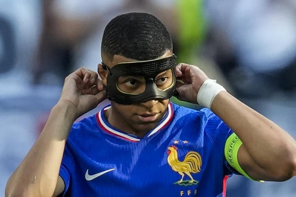 FILE - Kylian Mbappe of France adjusts his mask after scoring a penalty kick during a Group D match between the France and Poland at the Euro 2024 soccer tournament in Dortmund, Germany, on June 25, 2024. Kylian Mbappé has had more masks than goals at Euro 2024. Widely regarded as the heir to Lionel Messi and Cristiano Ronaldo as soccer's biggest icon, the France striker is struggling with his peripheral vision due to the protective face covering he has been fitted with since breaking his nose at the start of the European Championship. (AP Photo/Darko Vojinovic)