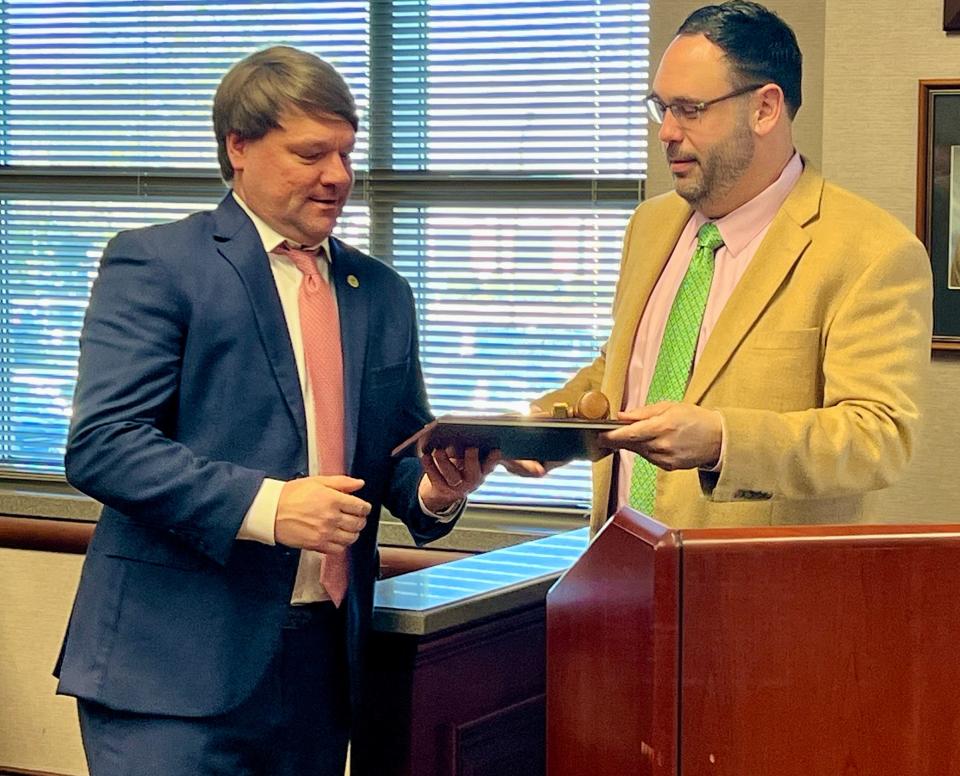 Shane Ellison, right, Etowah County's chief administrative officer, presents a plaque to outgoing Etowah County Commission Chairman Craig Inzer Jr. on Jan. 2, 2024, commemorating his year of service in the position.