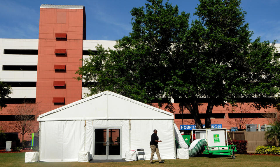 A security officer stands guard at a tent set up outside the emergency room at an AdventHealth hospital on March 17, 2020 in Orlando, Florida. The tent is part of AdventHealth's surge planning in case extra space is needed to care for potential coronavirus cases in the community. (Photo by Paul Hennessy/NurPhoto via Getty Images)