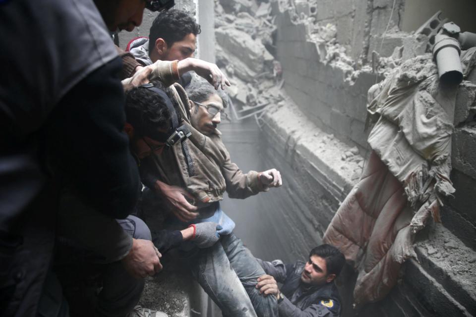 Civil defence rescue workers help a man from a shelter after an air strike in the besieged town of Douma in eastern Ghouta, 22 February 2018: Reuters