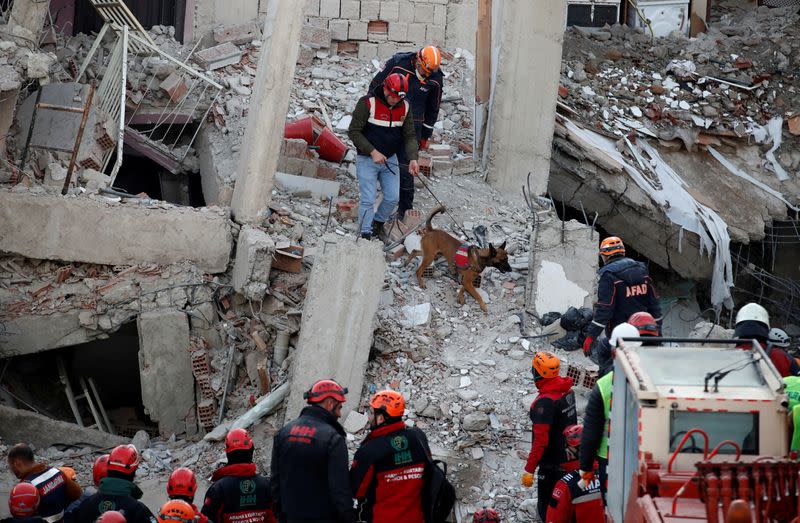 Rescue workers search the site of a collapsed building, after an earthquake in Elazig