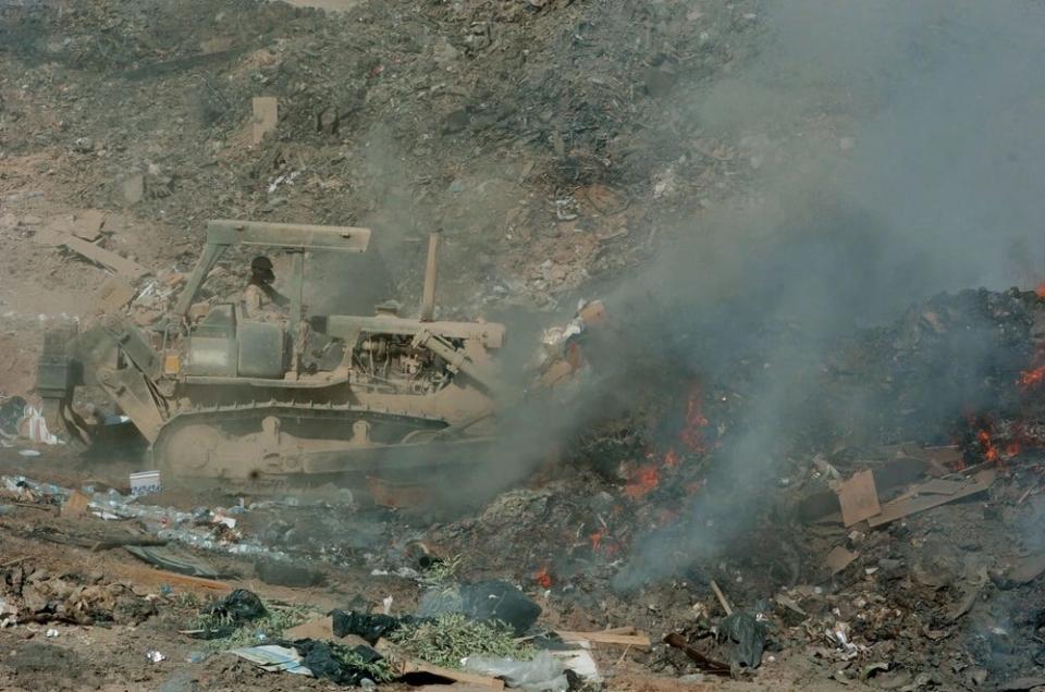 Sgt. Richard Ganske, of the 84th Combat Engineer Battalion, uses a bulldozer to maneuver refuse into the burn pit to manage Logistics Support Area Anaconda's sanitation requirements Sept. 24, 2004, in Balad, Iraq.