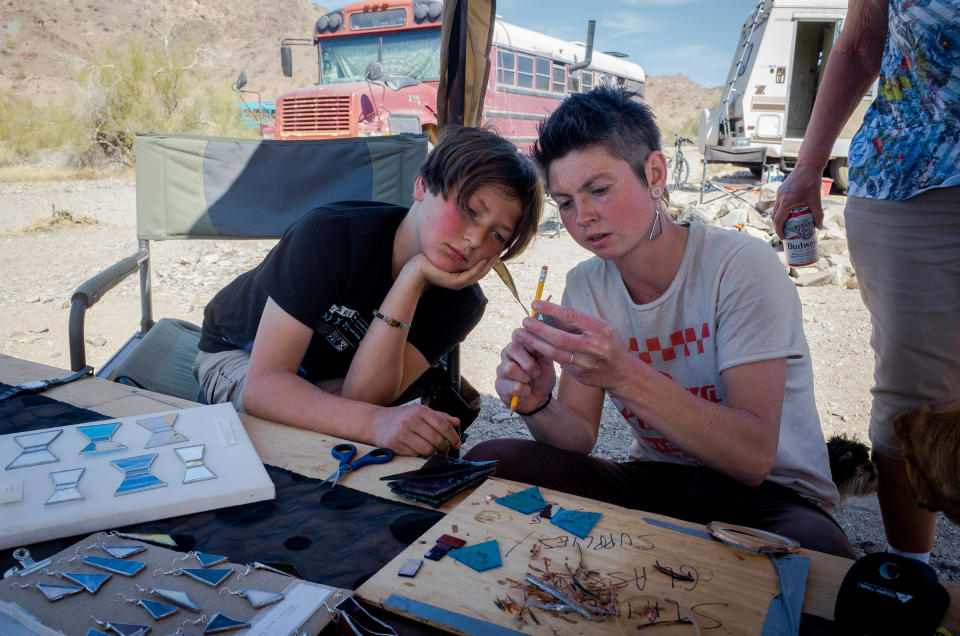 A stained glass artist teaches Max how to wrap the glass in copper foil on March 2. Paula says she and Max have found a community on the land unlike one they’ve ever had before. “We never go without,” she says. Neighbors parked nearby will still offer her extra tools or advice on a build, she says, or just ask her about her day. She’s learned about nearby jobs—including cleaning and painting houses—through word of mouth.<span class="copyright">Nina Riggio for TIME</span>