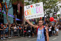 <p>Brandon Joyce carries a sign of remembrance for mass shooting victims in Orlando, at the 46th annual Los Angeles Gay Pride Parade in West Hollywood, Calif., June 12, 2016. (REUTERS/David McNew) </p>