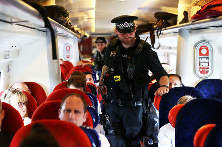 Armed police officers walk along the aisle of a train at Milton Keynes station, Britain May 25, 2017. REUTERS/Neil Hall