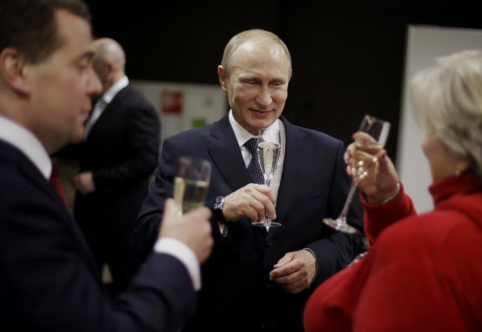 Russian President Putin toasts Russian Prime Minister Medvedev and figure skating coach Tarasova with glasses of champagne in presidential lounge before 2014 Winter Olympics closing ceremony in Sochi