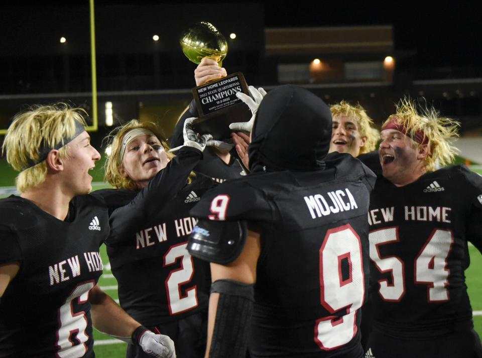 New Home lifts the Region I-2A Division I championship football trophy after the team's win against Wellington, Friday, Dec. 2, 2022, at Happy State Bank Stadium in Canyon.