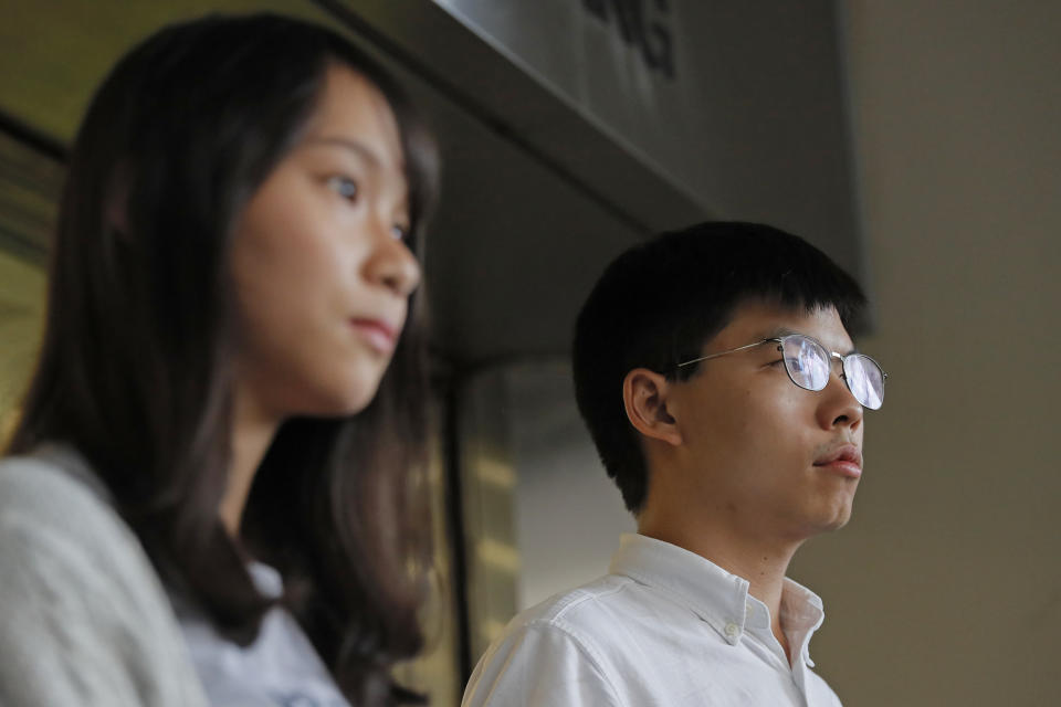 Pro-democracy activists Joshua Wong, right, and Agnes Chow speak to media outside a district court in Hong Kong, Friday, Aug. 30, 2019. Wong and Chow were granted bail Friday after being charged with inciting people to join a protest in June, while authorities denied permission for a major march in what appears to be a harder line on this summer's protests. (AP Photo/Kin Cheung)