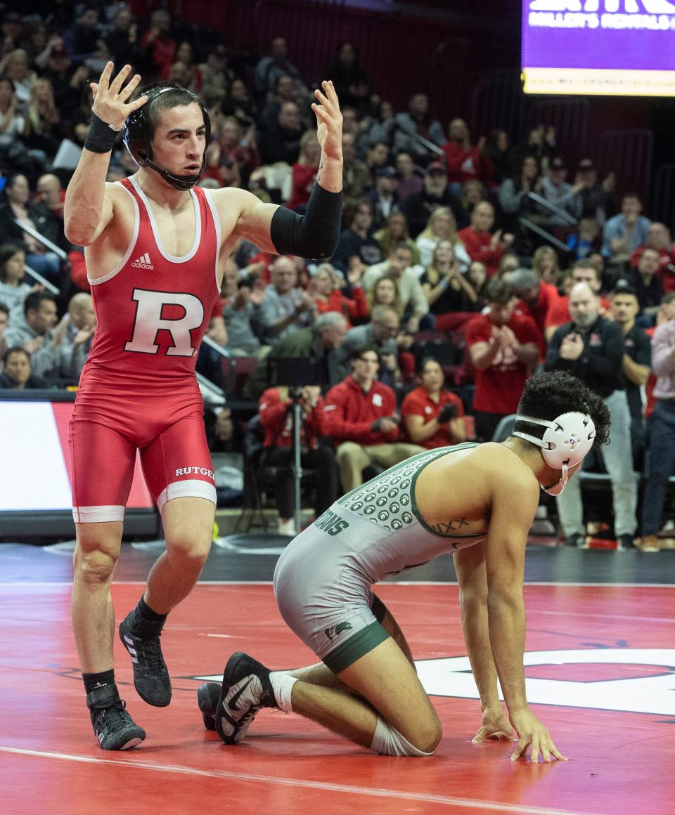 Rutgers' Dean Peterson exhorts the crowd after his 6-3 win at 125 pounds to begin the Scarlet Knights' 16-15 win over Michigan State Friday night.